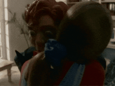 A Blurred Image Of A Man Holding A Child With A Bandana That Says ' A ' On It GIF