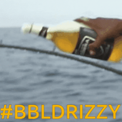 A Blurred Image Of A Person Holding A Beer Bottle With The Words #Bbldrizzy In Yellow Letters GIF