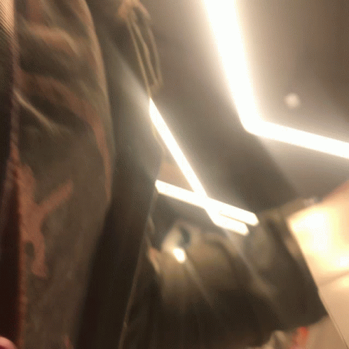 A Blurred Image Of A Person 'S Back With A Light Shining On It GIF