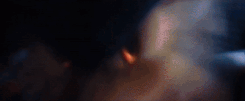 A Blurred Image Of A Person 'S Face In A Dark Room With Smoke Coming Out Of It . GIF