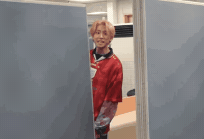 A Blurred Image Of A Person Standing Between Two Blue Dividers GIF