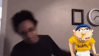A Blurred Image Of A Person Standing Next To A Puppet With A Yellow Shirt That Says Juan GIF