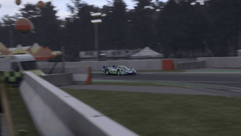 A Blurred Image Of A Race Car On A Track With A Sign That Says ' Heineken ' On It GIF
