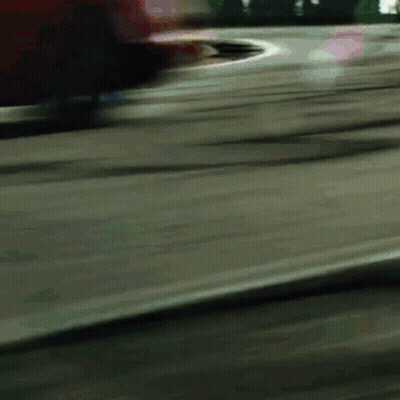 A Blurred Image Of A Red Car Driving Down A Road GIF