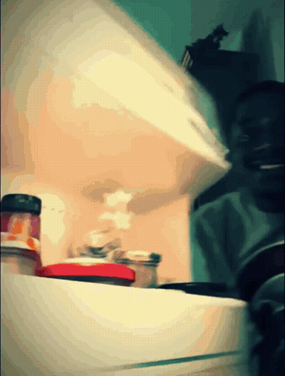 A Blurred Image Of A Refrigerator With Jars Of Food On The Shelf GIF