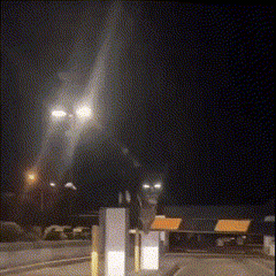 A Blurred Image Of A Street At Night With A Sign That Says ' Emergency Exit ' On It GIF