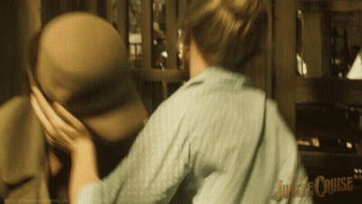 A Blurred Image Of A Woman Holding A Man 'S Hat With Jungle Cruise Written On The Bottom Right GIF