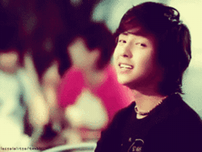 A Blurred Image Of A Young Man With A Necklace Around His Neck And A Black Shirt GIF