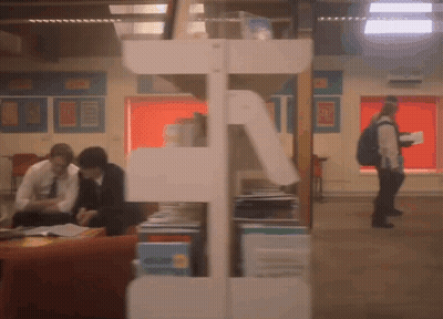 A Blurred Image Of People In A Library With A Sign On The Wall That Says ' A ' GIF