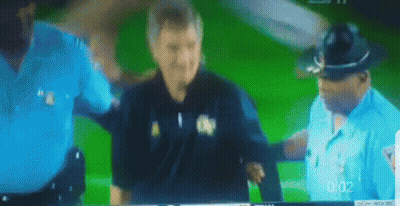 A Blurred Image Of Two Police Officers And A Man On A Green Screen With The Time 0:02 GIF