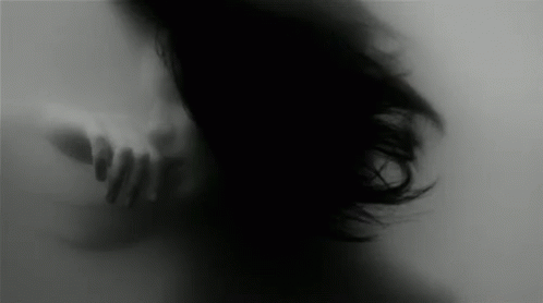 A Blurry Black And White Photo Of A Woman 'S Face Behind A Glass Wall . GIF