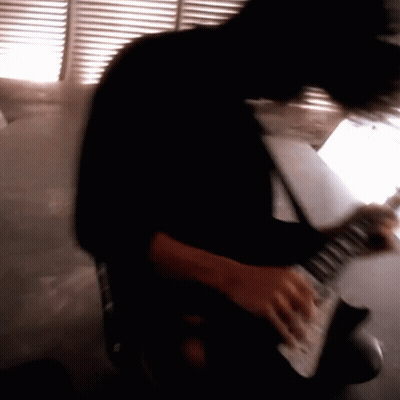 A Blurry Image Of A Person Playing An Electric Guitar GIF