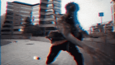 A Blurry Image Of A Person Standing On A Sidewalk With A Building In The Background GIF