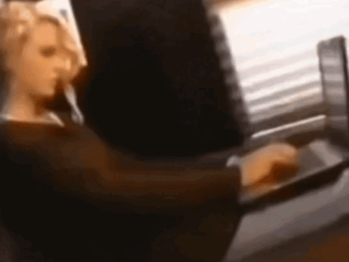 A Blurry Image Of A Woman Using A Laptop Computer GIF