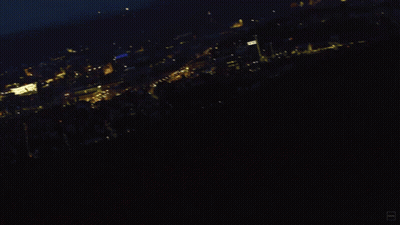 A Blurry Photo Of A City At Night With A Blue Sky GIF