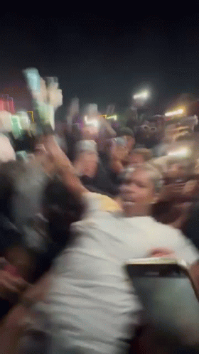 A Blurry Photo Of A Crowd Of People Dancing At A Party GIF