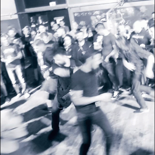 A Blurry Photo Of A Crowd Of People Dancing In Front Of A Sign That Says " Exit " GIF