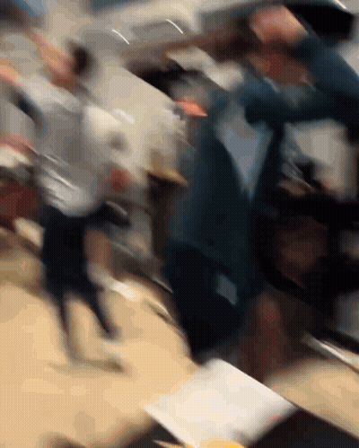 A Blurry Photo Of A Group Of People Dancing In A Room GIF
