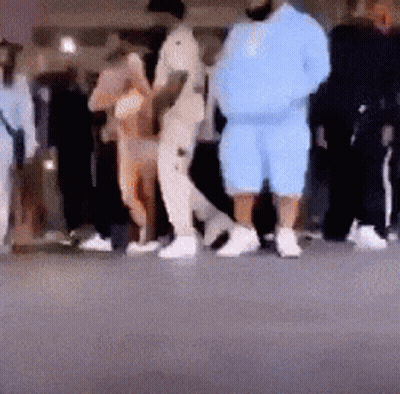 A Blurry Photo Of A Group Of People Standing On A Street . GIF