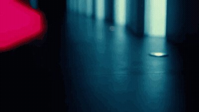 A Blurry Photo Of A Hallway With A Red Light In The Background GIF
