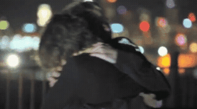A Blurry Photo Of A Man And Woman Hugging GIF