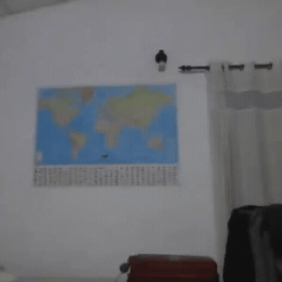 A Blurry Photo Of A Man Standing In Front Of A Map Of The World GIF