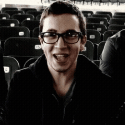A Blurry Photo Of A Man Wearing Glasses And A Black Coat GIF