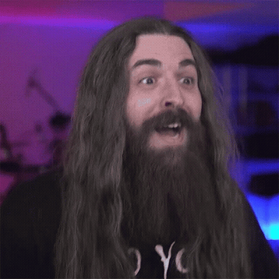 A Blurry Photo Of A Man With Long Hair And A Beard GIF