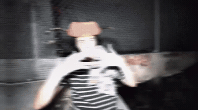 A Blurry Photo Of A Person Wearing A Cowboy Hat And A Striped Shirt GIF