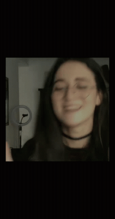 A Blurry Photo Of A Woman Wearing Glasses And A Choker . GIF