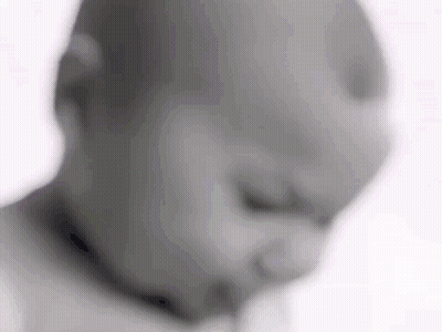 A Blurry Picture Of A Baby 'S Face With A Pacifier In His Mouth . GIF