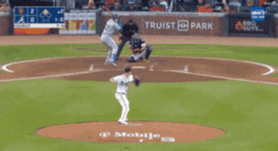 A Blurry Picture Of A Baseball Field With A Scoreboard Behind It GIF
