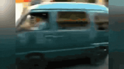 A Blurry Picture Of A Blue Van With A Man Driving GIF