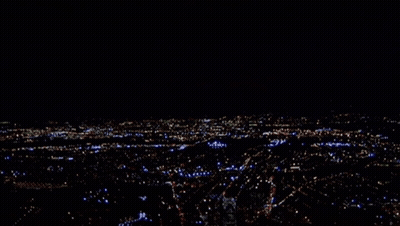 A Blurry Picture Of A City At Night With A Few Buildings Lit Up Including One That Says ' A ' GIF