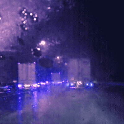 A Blurry Picture Of A City Street At Night With Purple Lights GIF