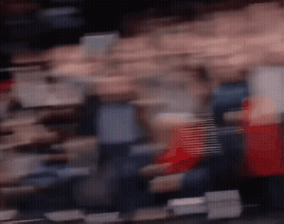 A Blurry Picture Of A Crowd Of People In A Stadium . GIF