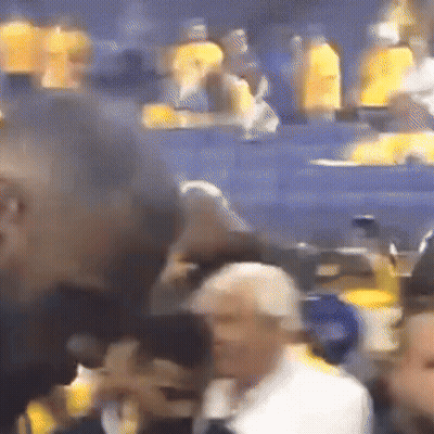 A Blurry Picture Of A Crowd Of People In A Stadium With Yellow Shirts On GIF