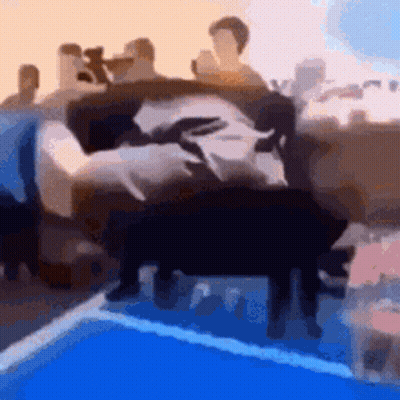 A Blurry Picture Of A Group Of People Sitting On A Couch In Front Of A Pool . GIF