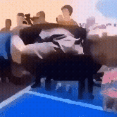 A Blurry Picture Of A Group Of People Standing Around A Swimming Pool . GIF
