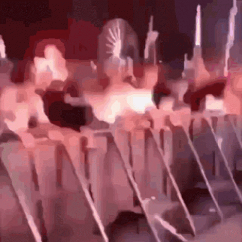 A Blurry Picture Of A Group Of People Standing In A Line GIF