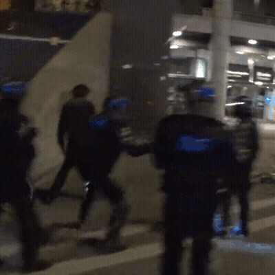 A Blurry Picture Of A Group Of Police Officers In Blue Uniforms GIF