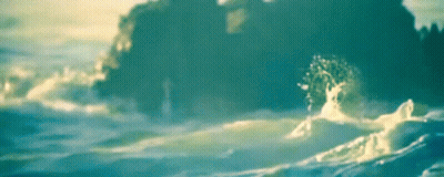 A Blurry Picture Of A Large Rock In The Ocean GIF
