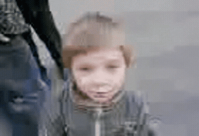 A Blurry Picture Of A Little Boy Holding A Person 'S Hand . GIF