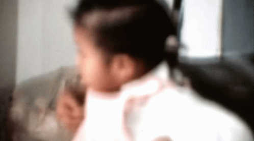 A Blurry Picture Of A Little Girl In A Pink Shirt GIF