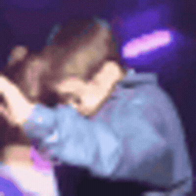 A Blurry Picture Of A Man And A Woman Hugging Each Other . GIF