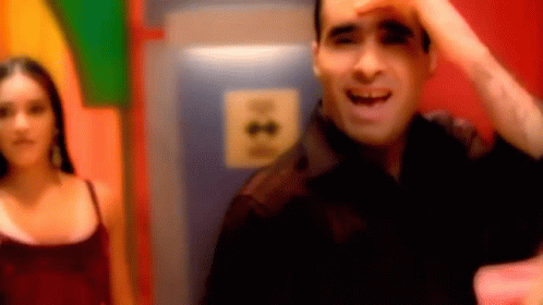 A Blurry Picture Of A Man And A Woman In A Room With A Sign That Says ' A ' On It GIF