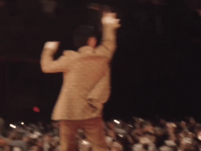 A Blurry Picture Of A Man Dancing On Stage In Front Of A Crowd . GIF