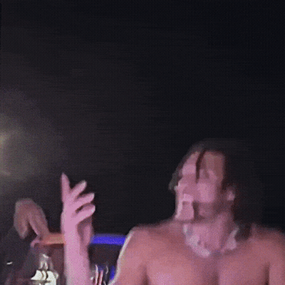 A Blurry Picture Of A Man Dancing With A Purple Light Behind Him GIF