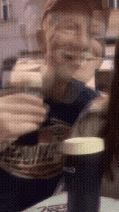 A Blurry Picture Of A Man Drinking From A Can Of Bud Light GIF