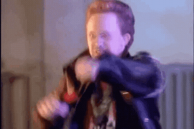A Blurry Picture Of A Man Holding A Gun In A Room . GIF